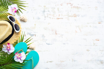 Summer cloth and accessories. Palm leaves, hat, flip flop and sunglasses on white background. Flat lay with copy space.