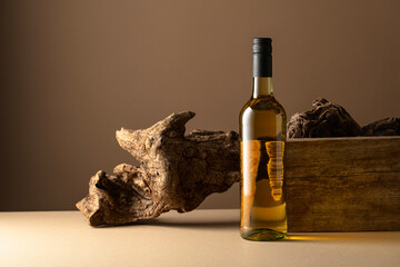 White wine and old snag on a beige background.