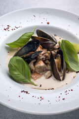 a dish of mussels and basil on a plate. Close up 