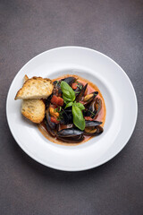 a dish of mussels and basil on a plate. Close up 