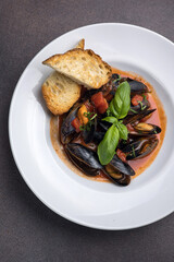 a dish of mussels and basil on a plate. Close up 