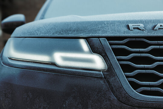 Gaydon, UK - Feb 11 2024 : Frozen detail closeup of a Range Rover velar HSE. JLR Luxury vehicle in cold weather. Detail of headlight covered in ice with lights on