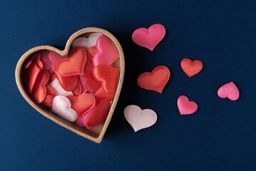 Fabric decorative hearts in heart-shaped box on dark-blue background. Valentine’s day greeting concept - obrazy, fototapety, plakaty