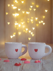 A red heart lovers coffee mug with cozy atmosphere and mini pink red heart,  with heart shape bokeh light in background. Valentine's day concept