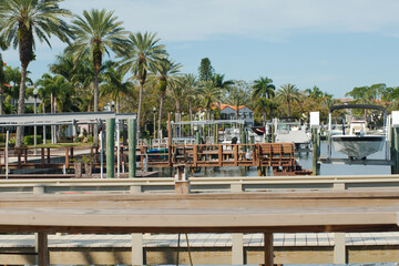 Horizontal View over various boat docks near Coffee Pot Bayou bay in St. Petersburg, Florida. Multiple Green Palm Trees on left. Blue and white sky in background.