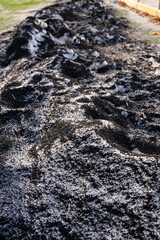 Artificial turf infill mixed with snow and ice by a football field.