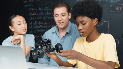 Smart teacher inspect car model construction to diverse student. Highschool children with mixed...