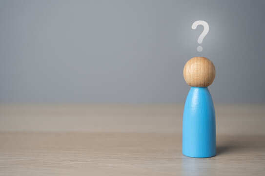 Man figurine with a question mark above his head. FAQ. Thoughts, reasoning and dreams. Introspection, asking yourself questions. Make plans and life goals. Search for answers. Doubts and fears.