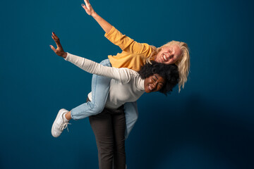 Diverse young women having a memorable time on a fun photo shooting in a studio.