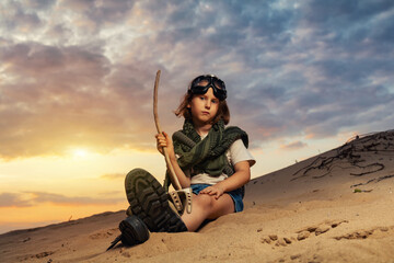 Little kid girl in goggles in sand desert 