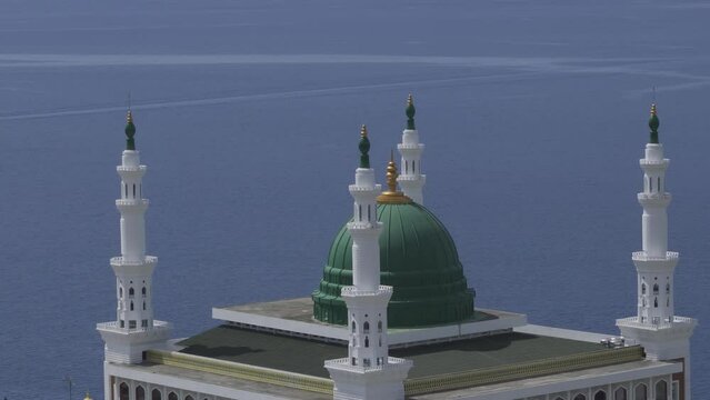 Aerial view of the magnificent beautiful Baitul Makmur Great Mosque, Tarempa. Mosque building by the sea with white paint and green dome. Eid al-Fitr Eid al-Adha Concept.