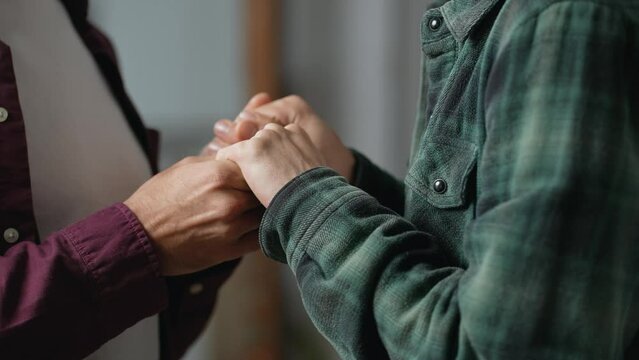 Close-up of gay couple holding hands tightly, romantic same-sex relationship, gesture of love and supporting. High quality 4k footage