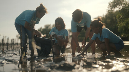 Group of volunteers cleaning on the beach - obrazy, fototapety, plakaty