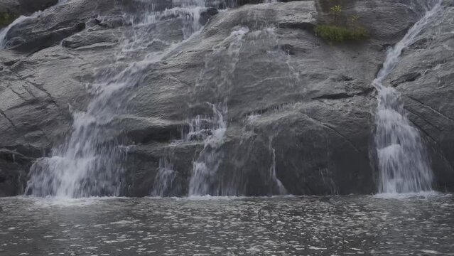 Temburun waterfall in Tarempa, Anambas Islands, Riau Archipelago, Indonesia surrounded by tropical forest. Multi layered waterfall cascade and rocky river stream.