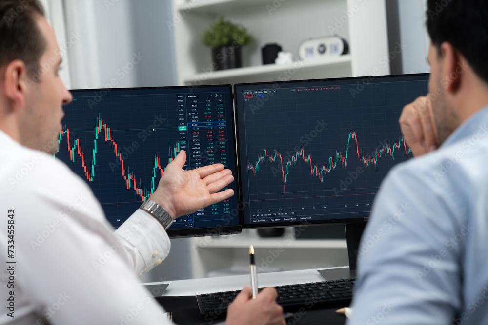 Poster stock traders discussing on research market stock database at real time by using two pc screen for c
