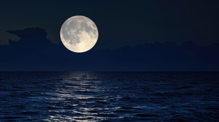 A full moon rising over a body of water.