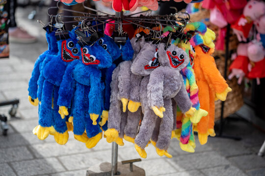 A bunch of Huggy Wuggy toys from the Poppy Playtime game franchise on sale during a local festive market. Popular gaming toys, plushies simple concept, closeup, nobody