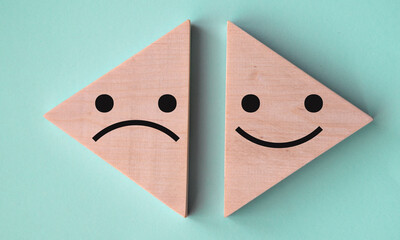 Pessimism and optimism - on wooden triangles on a gray-blue background.
