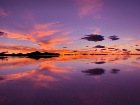 Sunset sky clouds above lake water. 