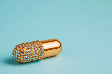 Golden capsule pill with diamonds. Expensive treatment concept, expensive medicine, medications, premium luxury healthcare. Rising drug prices. The best supplements, vitamins, essential microelements