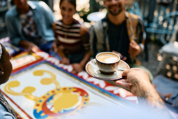 Close up of waiter serving coffee in cafe,