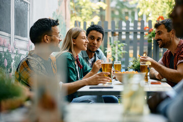 Young happy people talking while gathering in cafe.