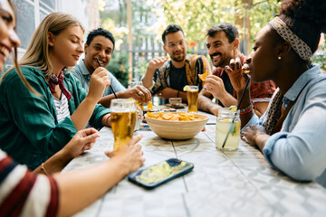 Group of young happy friends enjoying while gathering in cafe.