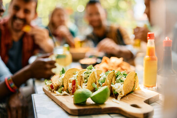 Ready to eat tacos with group of people in background at restaurant.