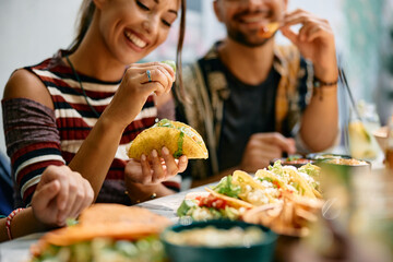 Close up of woman squeezing lime in her tacos while eating in Mexican restaurant.