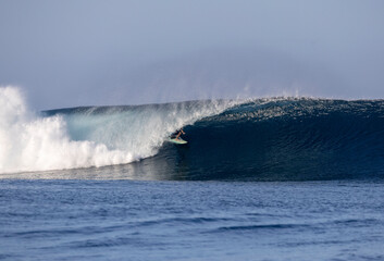 Surfer rides a clean wave in Fiji