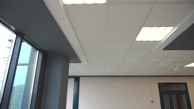 Square lamps on a white office ceiling. Interior design in the office. A fluorescent lamp on a modern suspended ceiling.
