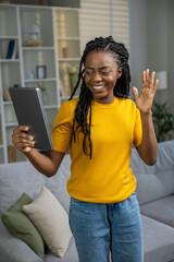 Cute smiling woman having a video call and looking contented