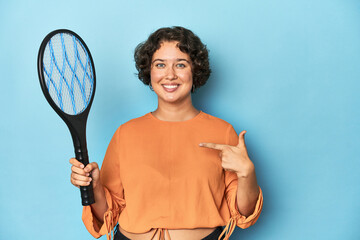 Young woman with electric mosquito racket Young woman with electric mosquito racketperson pointing...