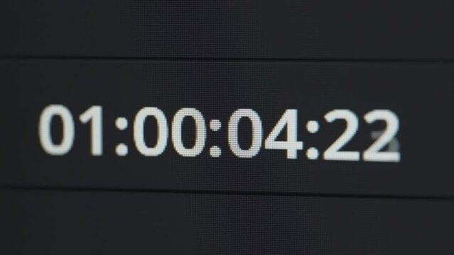 Time code running in a video editor software. Digital clock timer panel. Close up. 