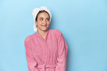 Woman in pink robe after shower dreaming of achieving goals and purposes