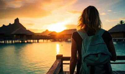 Crédence de cuisine en verre imprimé Bora Bora, Polynésie française Tropical Serenity: Back View of a Happy Tourist Woman Relaxing on the Deck of an Overwater Bungalow in Bora Bora, Embracing the Tranquil Beauty of Sunset Over the Turquoise Lagoon.  