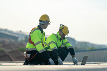 Worker Technicians are working to construct solar panels system on roof. Installing solar photovoltaic panel system. Men technicians carrying photovoltaic solar modules on roof.