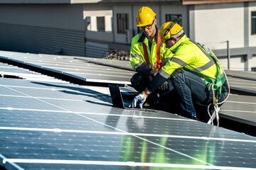 Worker Technicians are working to construct solar panels system on roof. Installing solar photovoltaic panel system. Men technicians carrying photovoltaic solar modules on roof.