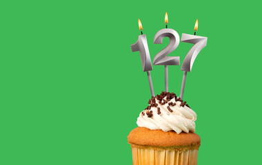 Birthday card with candle number 127 - Cupcake on green background