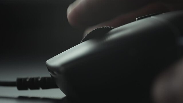 Finger scrolling with a black mouse wheel. Close up. 