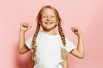 Smiling young girl showing strength with flexed arms