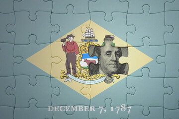 puzzle with the national flag of delaware state and usa dollar banknote. finance concept