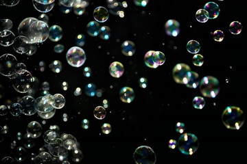 Glowing soap bubbles on black background.