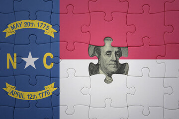 puzzle with the national flag of north carolina state and usa dollar banknote. finance concept