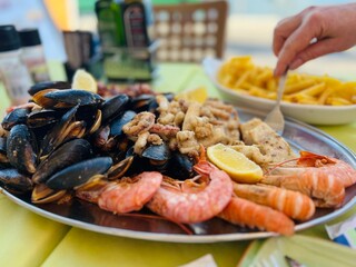 Grilled shrimps and mussels with salad on a plate. Tasty seafood salad with shrimps and mussels on the table