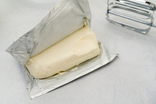Unpucked brick of a cream cheese close-up on a kitchen table