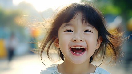 Happy Little Asian Girl child shows front teeth with a big smile and laughs: funny smiley face, healthy smiley face, cute smiley face, cute kid.Joyful girl of an Asian primary school student - obrazy, fototapety, plakaty