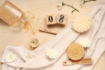 Fototapeta na wymiar Composition with spa accessories, flowers and calendar with date of International Women's Day on wooden background
