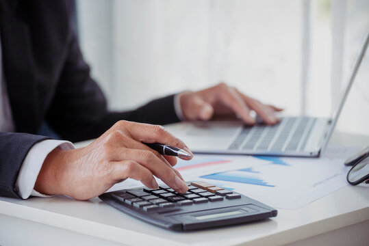 Close up business man hands using calculator counting tax financial bill. Man hands calculating number, data, graph, chart audit planning accountancy on business report. Tax audit Finacial concept.