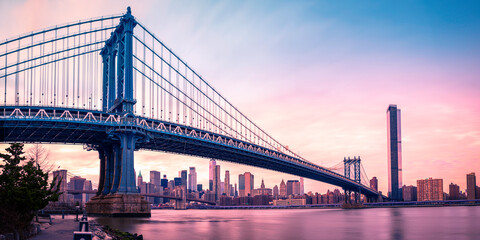 New York City Skyline and Manhattan Bridge over the East River at sunset, a suspension bridge...